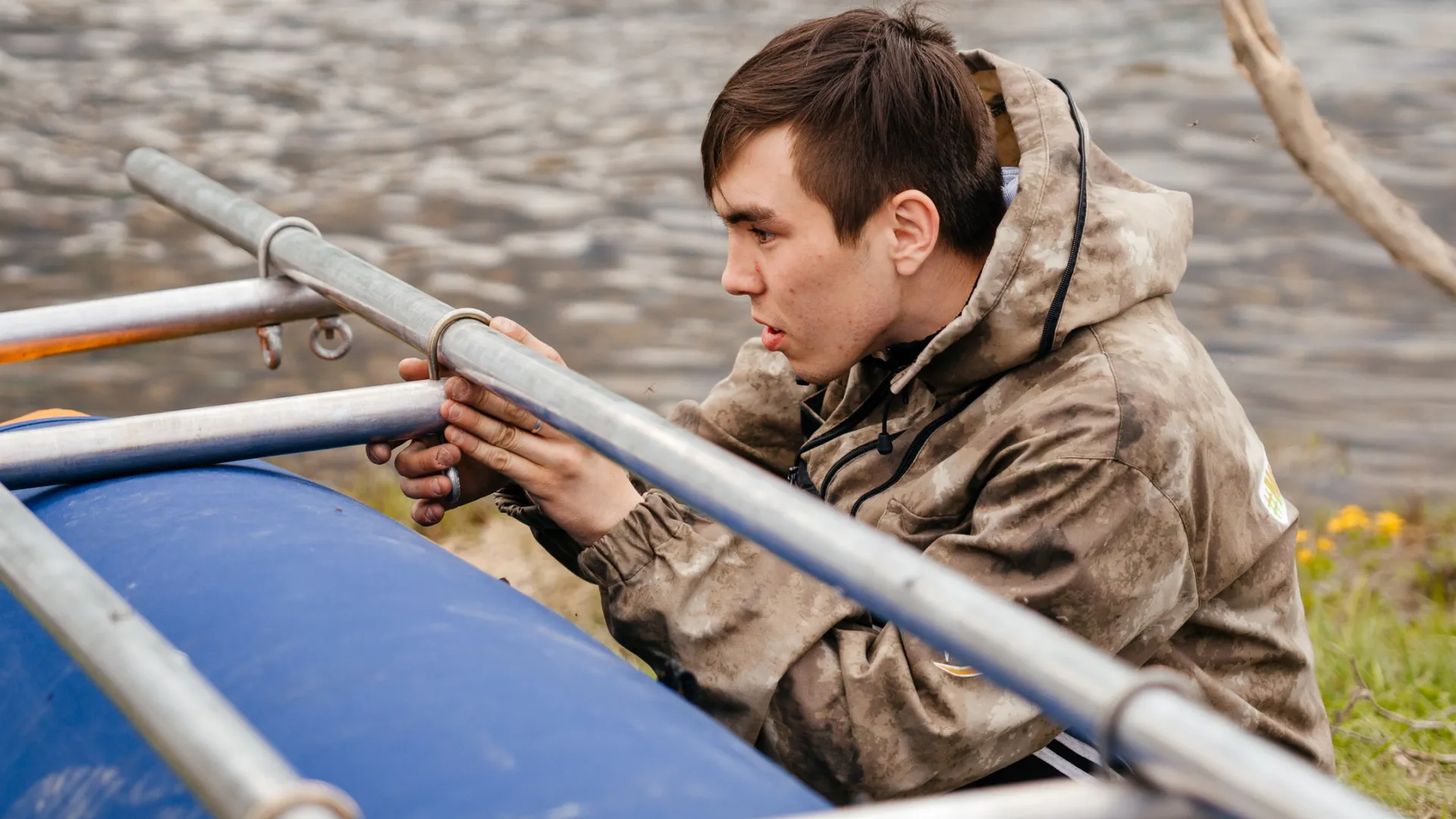Участник сплава учится устанавливать каркас на баллон катамарана. Фото: Юлия Чудинова 